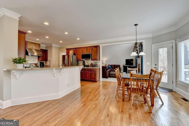 dining room featuring ornamental molding and light hardwood / wood-style floors