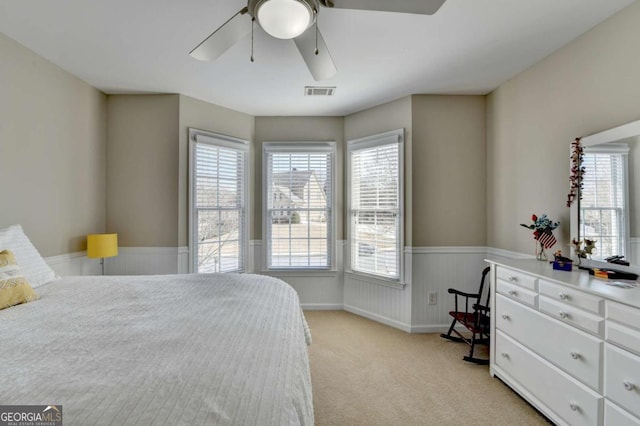 carpeted bedroom featuring multiple windows and ceiling fan