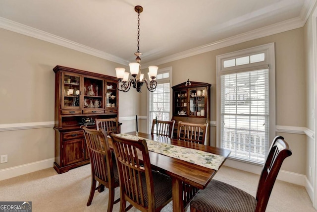 dining room with an inviting chandelier, ornamental molding, and light colored carpet