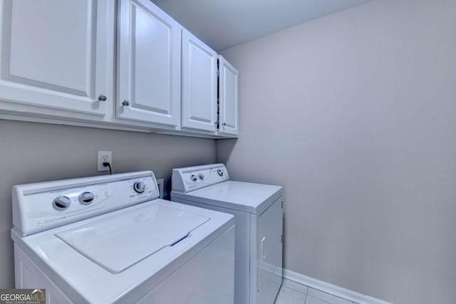 laundry area featuring cabinets, washing machine and dryer, and light tile patterned floors