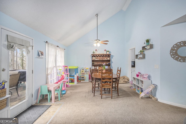 carpeted dining room featuring ceiling fan and high vaulted ceiling