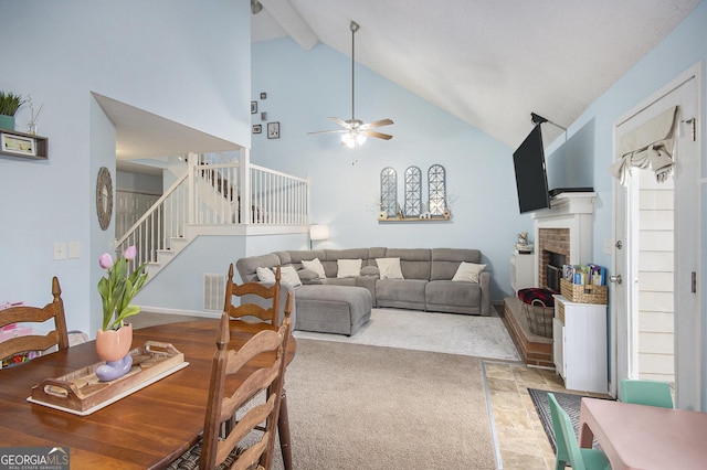 living room featuring beamed ceiling, ceiling fan, a fireplace, and high vaulted ceiling