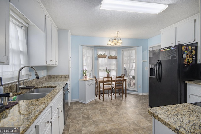 kitchen featuring white cabinetry, sink, hanging light fixtures, and black appliances