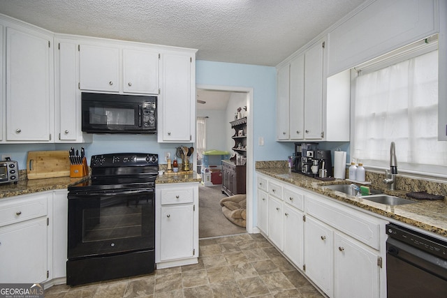 kitchen featuring white cabinetry, sink, black appliances, and dark stone counters