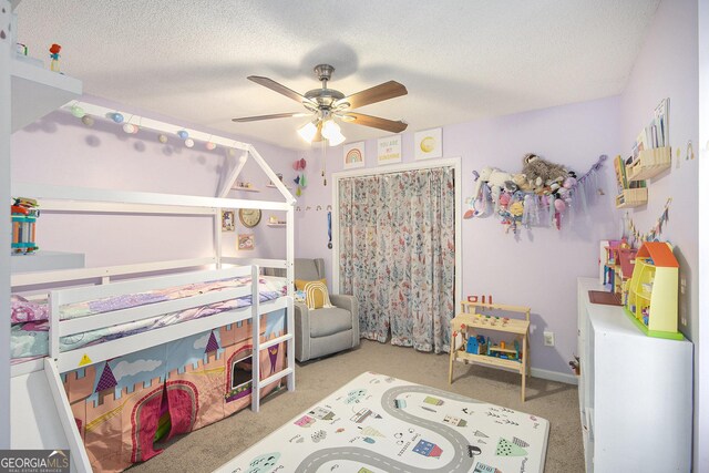 carpeted bedroom featuring ceiling fan, a closet, and a textured ceiling