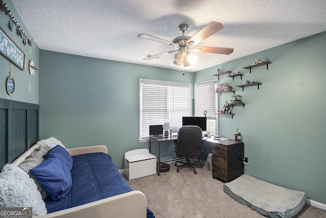 carpeted office with a textured ceiling and ceiling fan