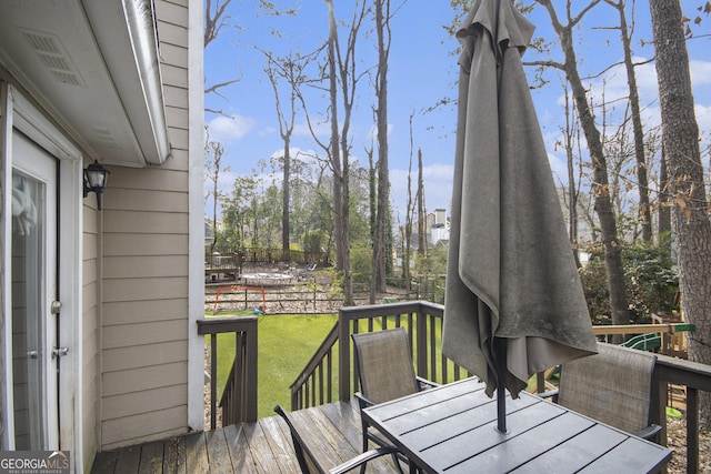 wooden terrace featuring a lawn