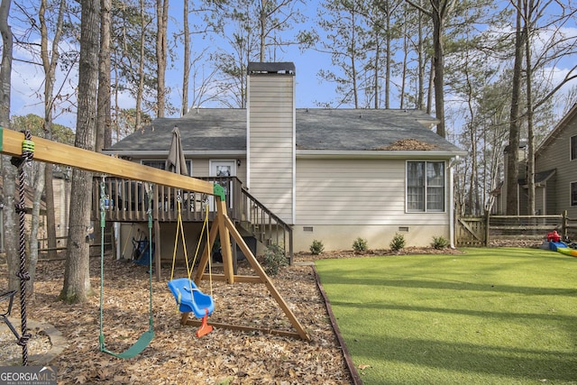 rear view of house featuring a wooden deck and a lawn