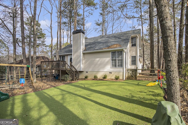 back of house with a lawn, a playground, and a deck