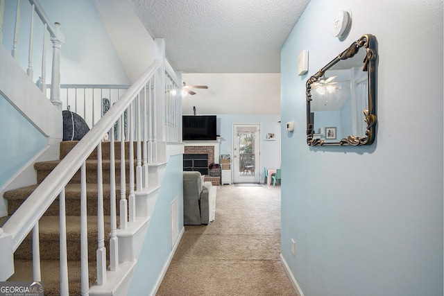 corridor with light carpet and a textured ceiling