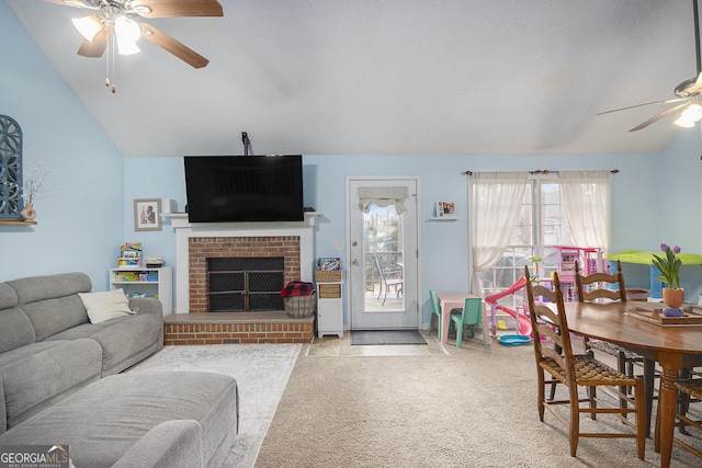 carpeted living room with ceiling fan, vaulted ceiling, and a brick fireplace