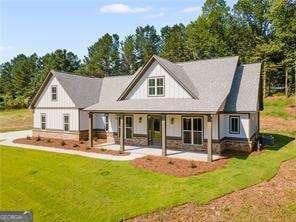 rear view of house with a patio and a lawn
