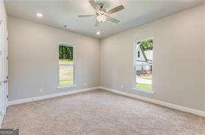 carpeted empty room with ceiling fan