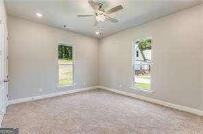 carpeted spare room with a ceiling fan, baseboards, and recessed lighting