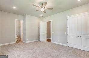 unfurnished bedroom featuring ceiling fan and light carpet