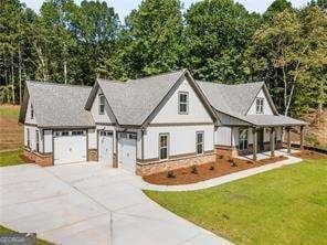 modern farmhouse with an attached garage, concrete driveway, and a front yard