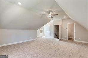 bonus room featuring lofted ceiling, carpet floors, and ceiling fan