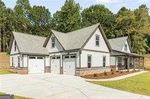 view of front of house featuring a garage, a front yard, and covered porch