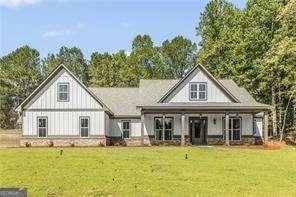 rear view of house featuring a lawn and covered porch
