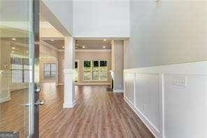 interior space featuring a decorative wall, wood finished floors, and wainscoting