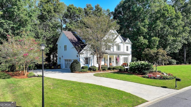 view of front of property featuring a porch, a garage, and a front lawn