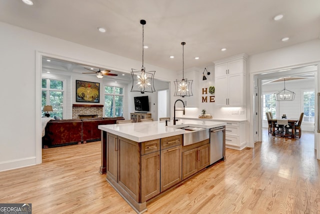 kitchen featuring white cabinetry, sink, an island with sink, and dishwasher