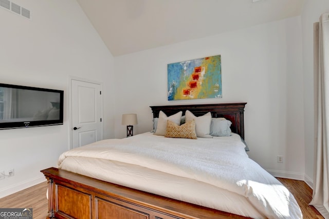 bedroom featuring lofted ceiling and hardwood / wood-style flooring