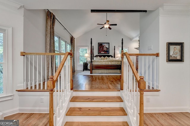 stairs with hardwood / wood-style flooring, lofted ceiling, and ceiling fan