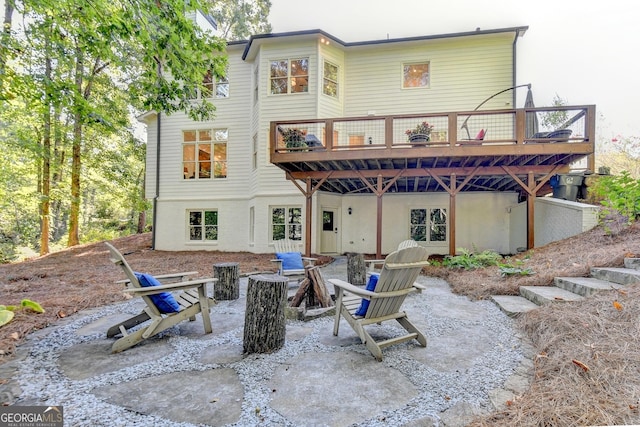 rear view of house featuring a patio, a deck, and an outdoor fire pit