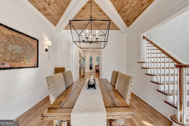 dining room with ornamental molding, light wood-type flooring, a chandelier, and wood ceiling