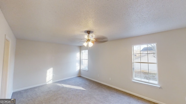 carpeted empty room featuring a textured ceiling and ceiling fan