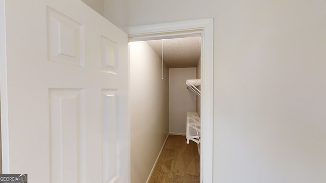 corridor with a textured ceiling and carpet flooring