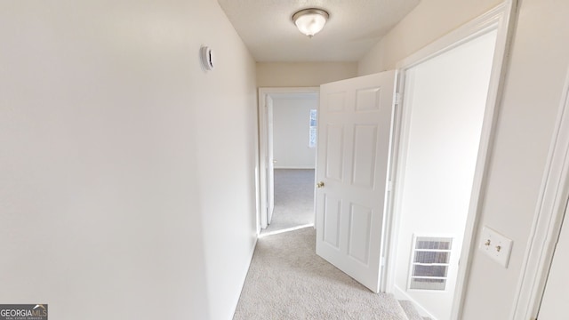 hall featuring light colored carpet