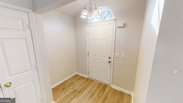 entryway with hardwood / wood-style floors and a chandelier