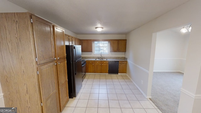 kitchen with light tile patterned flooring, sink, and black appliances