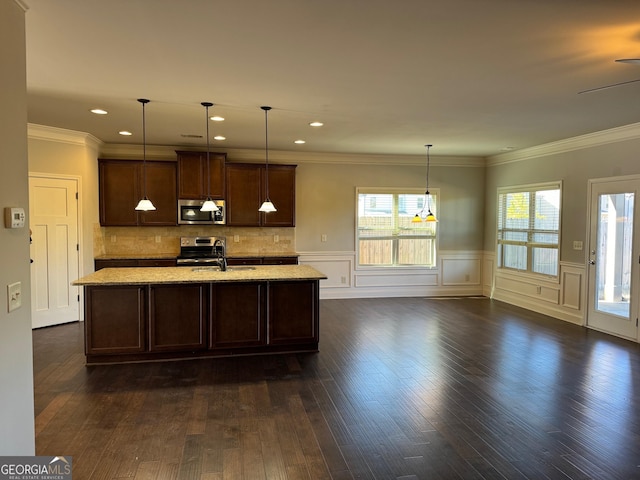 kitchen with pendant lighting, stainless steel appliances, dark hardwood / wood-style floors, light stone counters, and a center island with sink