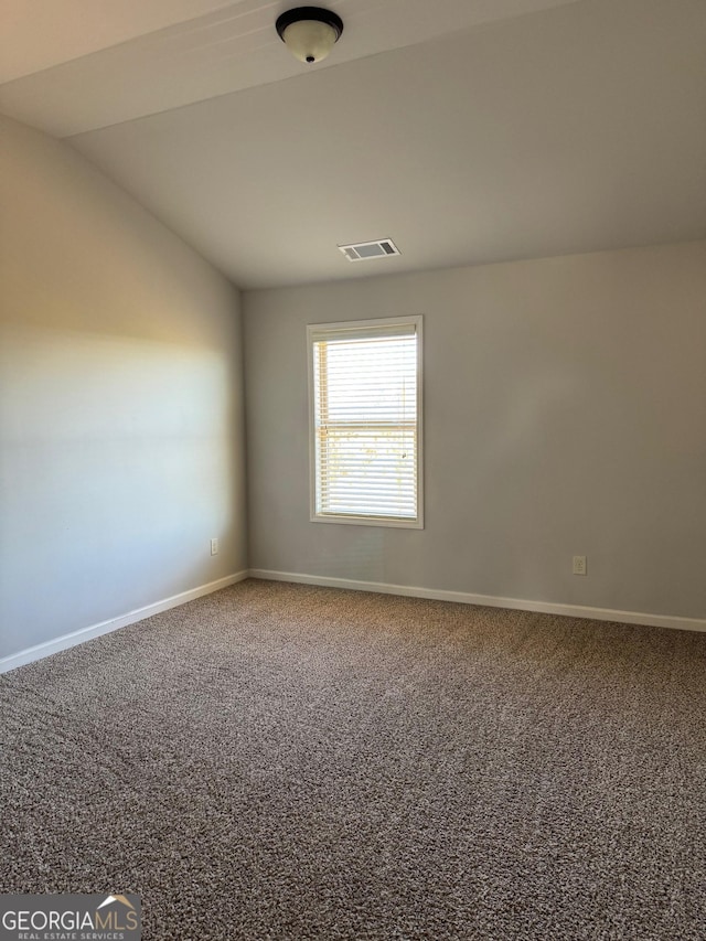 carpeted empty room with lofted ceiling