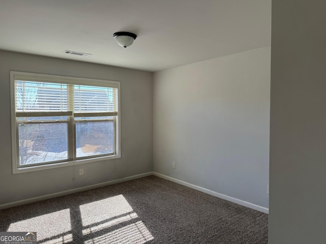 unfurnished room with dark carpet