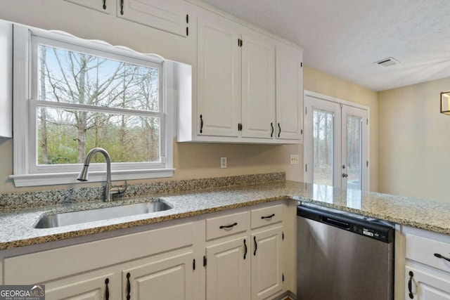 kitchen with white cabinetry, sink, stainless steel dishwasher, and light stone countertops