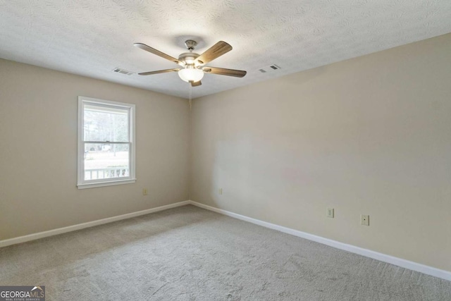 unfurnished room with a textured ceiling, carpet floors, and ceiling fan