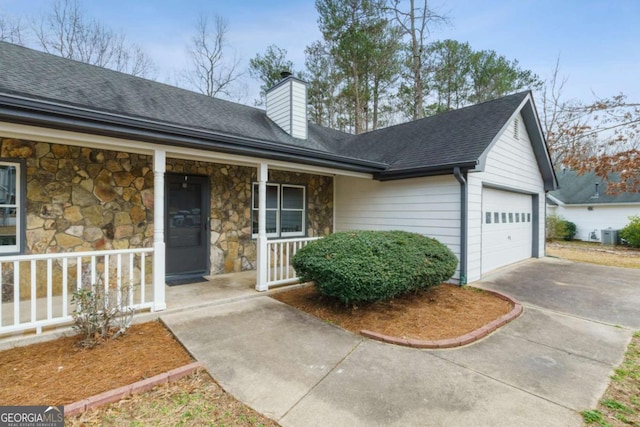 view of front facade with a garage, central AC unit, and covered porch