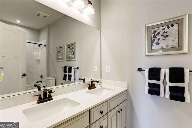 full bathroom featuring vanity, tiled shower / bath combo, and toilet