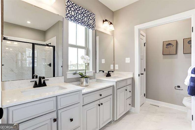 bathroom featuring vanity, toilet, and an enclosed shower