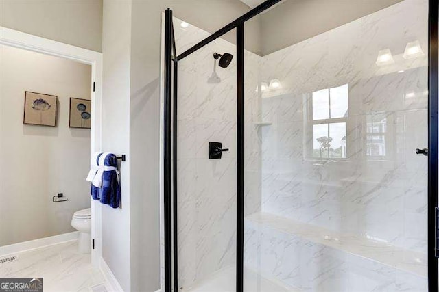 bathroom featuring toilet and a shower with shower door