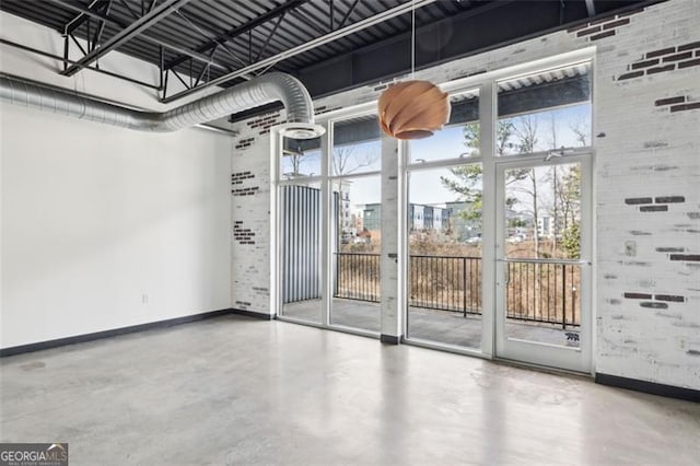 interior space featuring brick wall and concrete floors