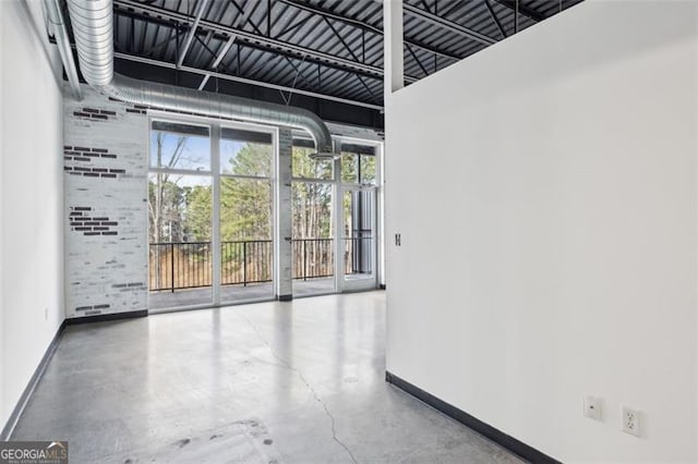 spare room with brick wall and concrete flooring