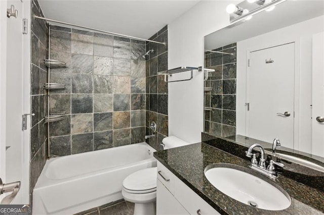 full bathroom featuring tiled shower / bath, vanity, and toilet