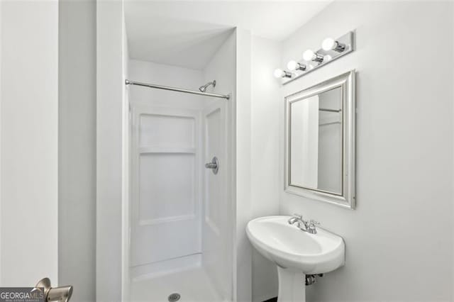 bathroom with walk in shower and sink