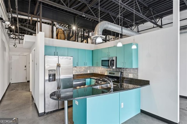 kitchen featuring blue cabinetry, hanging light fixtures, concrete floors, kitchen peninsula, and stainless steel appliances