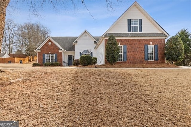 view of front of property featuring brick siding and fence